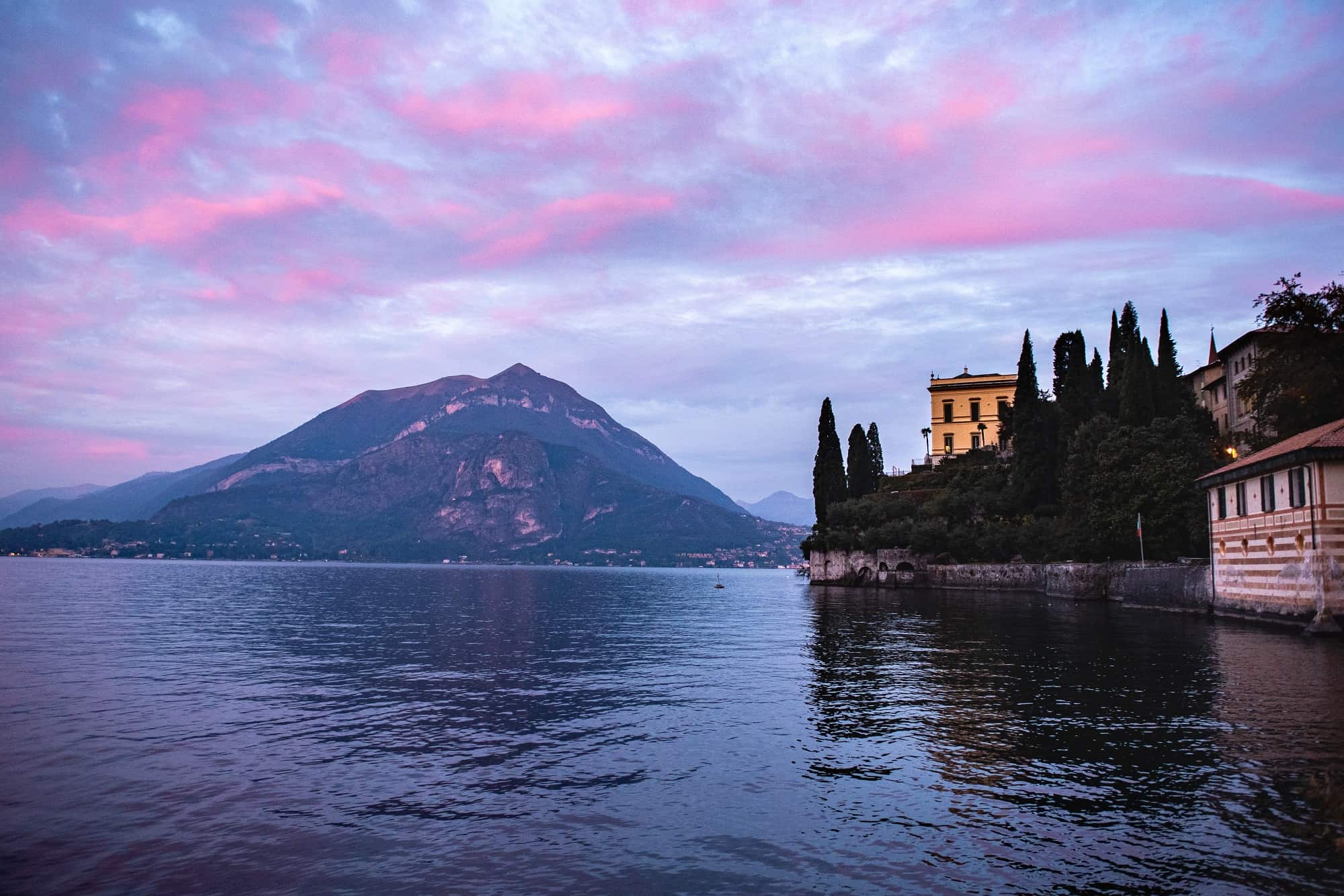 sunrise on lake como in italy, pink blue skies with villa cipressi pm the right
