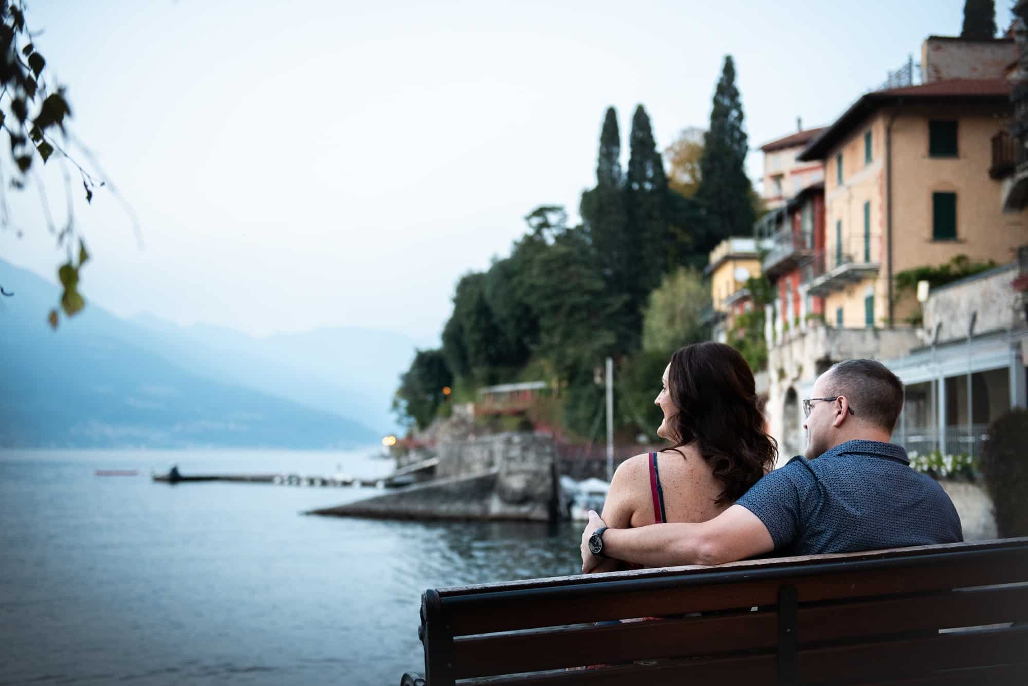 bride and groom sat on a bench overlooking lake como, the night beofre their wedding