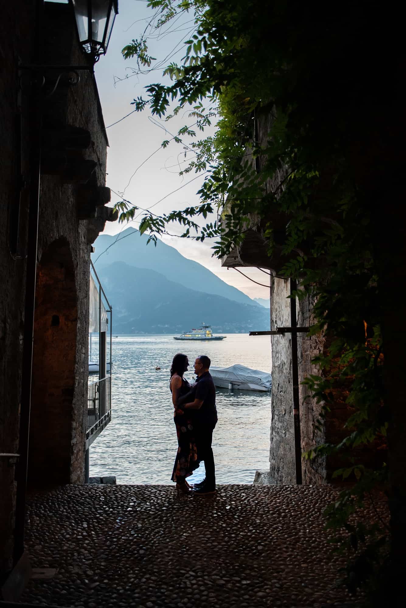 overlooking the lake through an alleyway with the bride and groom silhouetted